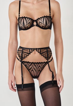 Black lace lingerie set featuring a scalloped bra with sheer mesh, a garter belt with intricate detailing, and thigh-high stockings.