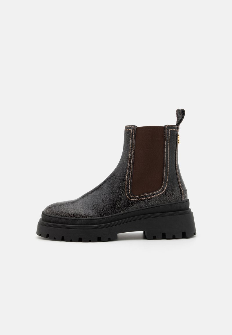 Bottes Chelsea en cuir noir avec panneaux élastiques latéraux marron, semelle épaisse et surpiqûres contrastées. Dotées d'une languette à l'arrière.