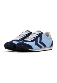 Ténis desportivos com tecido azul claro e camurça azul escuro, atacadores brancos e solas de borracha preta. Design distinto com riscas nas laterais.