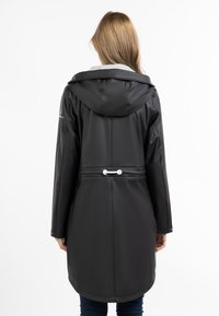 Parka nera impermeabile con cappuccio, dotata di vita regolabile, texture liscia e colletto grigio a contrasto.