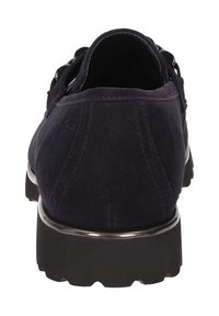 Marineblauwe suede instapper met zwarte dikke zool, zilveren afwerking en een zijsluiting, weergegeven vanuit achteraanzicht.