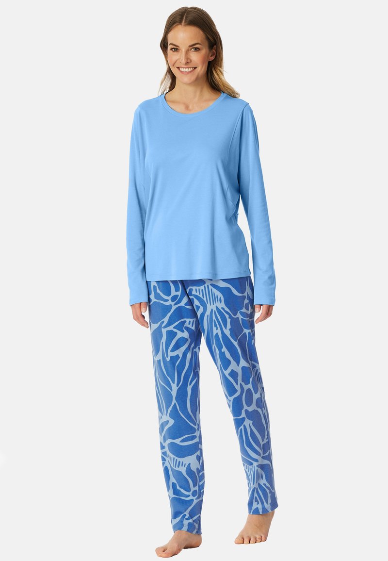 Top de manga larga azul claro combinado con pantalones azules estampados con diseños abstractos en blanco. Tela suave, ajuste relajado y pantalones de largo completo.