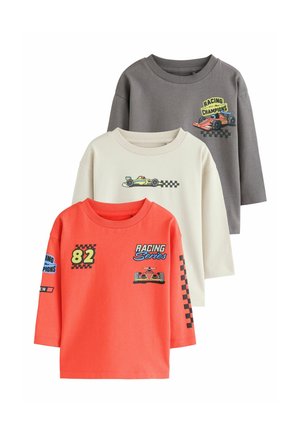Trois chemises à manches longues pour enfants en gris, blanc cassé et orange, chacune avec des motifs de voiture de course et de drapeau à damier.