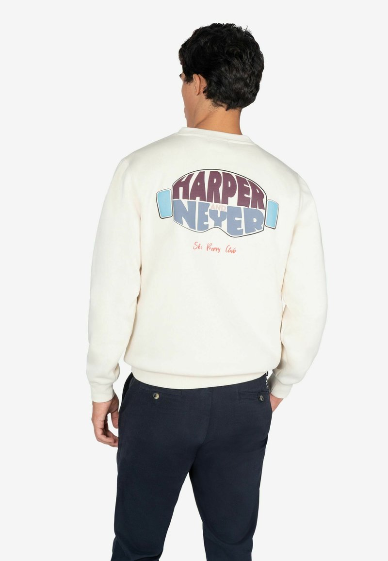Kremowa bluza z dużą, wielokolorową grafiką na plecach z napisem "HARPER i NEYER". Ribnowe mankiety i dół.
