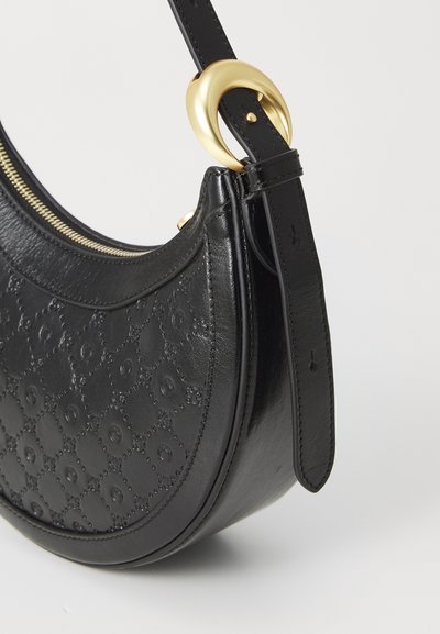 Sort læder skuldertaske med en buet form, præget mønster, gold hardware detaljer og lynlås lukning langs toppen.
