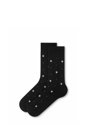 Paar schwarze Socken mit einem kleinen weißen Wolfs-Gesichtsmuster, gleichmäßig über den Stoff verteilt, auf weißem Hintergrund dargestellt.