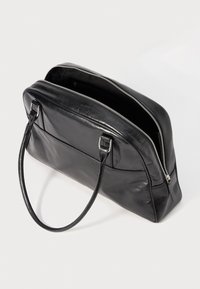 Black leather handbag with two handles, silver zipper partially open, rectangular shape, and front external pocket on a white background.