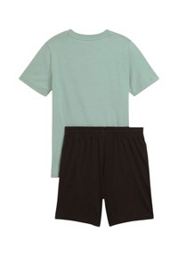 Camiseta de algodón verde claro con mangas cortas y escote redondo, combinada con pantalones cortos negros que cuentan con una cintura elástica.