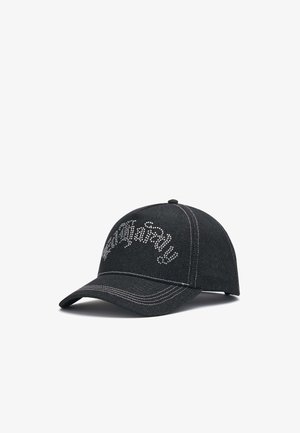 Gorra de béisbol negra con costuras blancas y texto en cursiva adornado con pedrería en el panel frontal sobre fondo blanco.