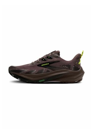 Bruine Brooks hardloopschoen met gestructureerde zool, mesh bovenwerk, neon gele accenten en "BROOKS" en "TRAILTACK" branding.
