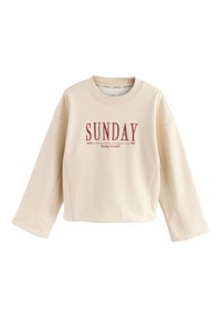 Crèmekleurige sweatshirt met lange, wijde mouwen en een ronde halslijn. Voorzien van rode tekst "SUNDAY" en "Social Society since 1982."