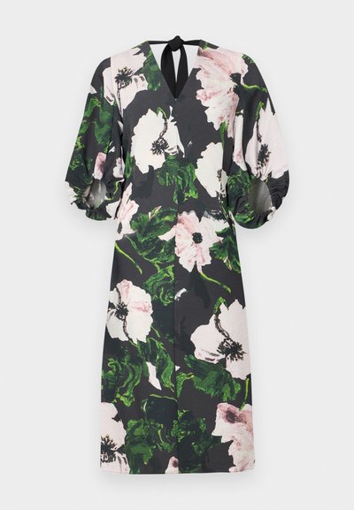 Vestido floral com fundo preto; apresenta grandes padrões de flores rosas e verdes, decote em V, mangas bufantes e um laço nas costas.