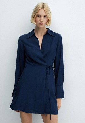 Rochie închiată la culoare, de un albastru marin, cu guler ascuțit, mâneci lungi, detaliu cu șnur la talie și o textură netedă, concepută cu o fustă ușor evazată.