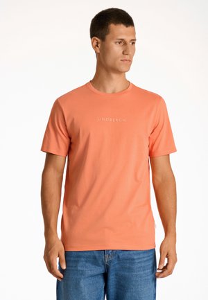 Korte mouw, koraaloranje t-shirt van een zachte stof, met een ronde halslijn en een 'LINDENBERGH' logo in lichte kleur op de voorkant.
