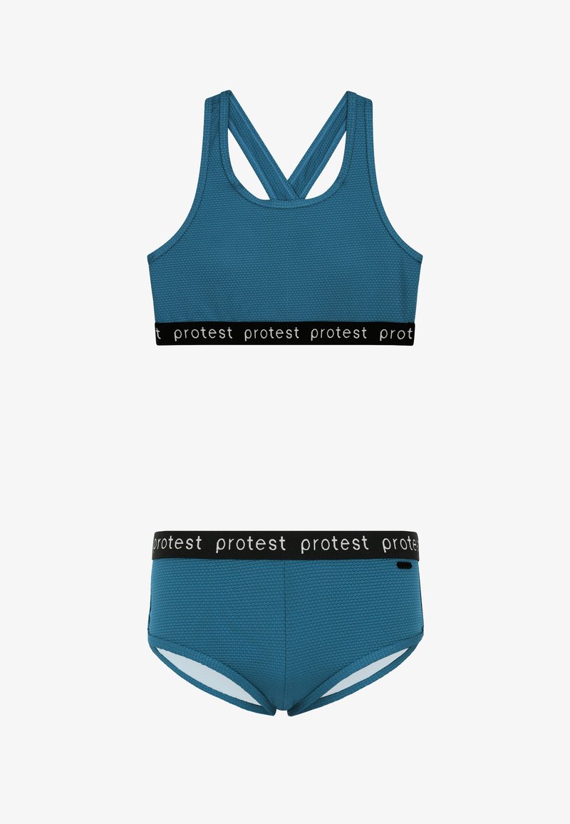 Plavi sportski grudnjak sa strukturiranom teksturom i ukriženim naramenicama, crni elastični pojas sa natpisom "protest." Usklađen plavi badić sličnog pasa.