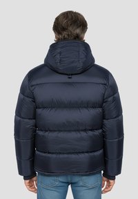 Doudoune bleu marine avec matelassage horizontal, capuche et poignets élastiques. Fabriquée en matériau brillant et léger, offrant chaleur et isolation.