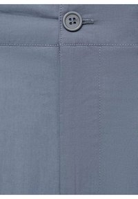 Pantaloni grigi con una texture di tessuto liscia, chiusura frontale con bottone e cuciture ordinate lungo le cuciture.
