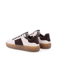 Baskets en cuir blanc avec des accents en daim brun foncé, dotées d'une semelle en gomme texturée et de lacets plats. Bout arrondi et col rembourré.