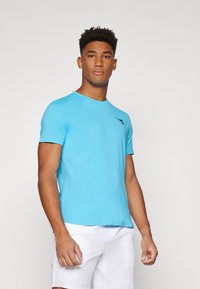 Helles blaue T-Shirt mit kurzen Ärmeln für den Sport, mit strukturierten Streifen und einem schwarzen Logo auf der Brust, hergestellt aus einem feuchtigkeitsableitenden Stoff.