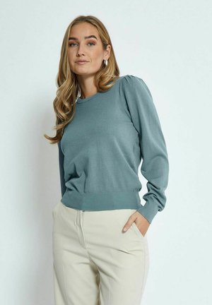 Teal knitted sweater with long sleeves, crew neckline, ribbed hem, and subtle puff detailing at the shoulders, paired with beige trousers.