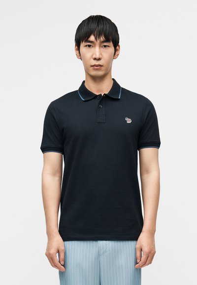 Polo bleu marine en coton, avec col, manches courtes et petit motif brodé sur la poitrine.