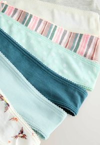 Fem sammenfoldede dameundertøj i pastelfarver med mønstre, herunder striber, prikker, ensfarvede og fugle på hvid baggrund.