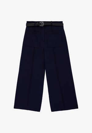 Pantalones anchos de color azul marino con dos grandes bolsillos delanteros y un cinturón delgado negro con una hebilla plateada en la cintura.