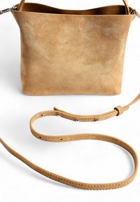 Borsa a spalla in suede color corda con una finitura liscia e texturizzata, dotata di tracolla regolabile e design minimalista, posizionata in verticale.