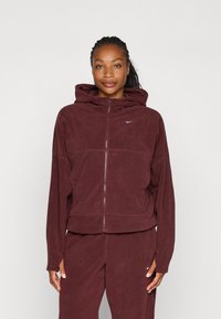 Bordo flis zip-up dukserica s visokim ovratnikom, prednjim dzepovima i malim bijelim logotipom na gornjoj lijevoj strani. Mekana tekstura, širok kroj.