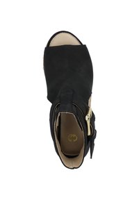 Black suede open-toe shoe with a short heel. Features a gold buckle and a tan interior. Simple design with a strap across the foot.