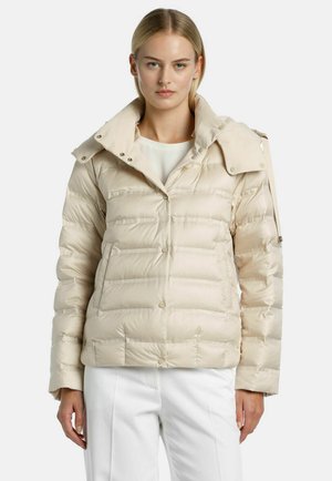Beige puffer jacket with a high collar, snap buttons, and quilted texture. Features a one-button sleeve detail and a front closure.