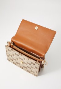 Brown leather handbag with a beige patterned fabric exterior, featuring a gold clasp, zipper pocket, and chain accent. Opened view.
