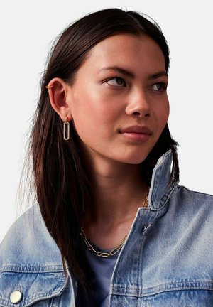 Guldtonede hoops med rektangulært, struktureret detalje; båret med en denimjakke. Kæde ved kraven.