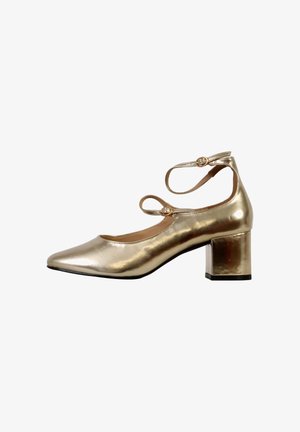 Chaussure à talon métallique doré avec un bout pointu, des brides de cheville avec des boucles rondes et un talon carré pour plus de stabilité. Texture lisse sur l'ensemble.