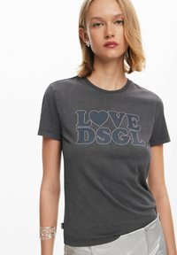 Grijze tshirt met korte mouwen, voorzien van een decoratief ontwerp "LOVE DSGL" omrand met kleine rhinestones. Soepele katoenen stof, eenvoudige ronde halslijn.