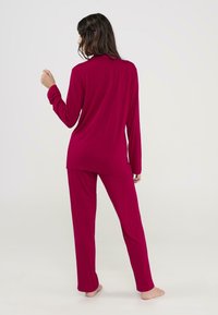 Conjunto de pijama de manga larga, holgado, en color burdeos, hecho de una tela suave, con una silueta relajada y pantalones de largo completo.