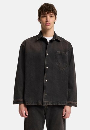 Sort denimjakke med en rummelig pasform, der har en spids krave, frontlomme og trykknaplukning. Slidt tekstur med let fading.