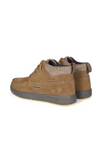 Bottines en daim marron avec une doublure en feutre gris doux, des accents jaunes et une semelle en caoutchouc grise. Les caractéristiques incluent des lacets et une languette au talon.