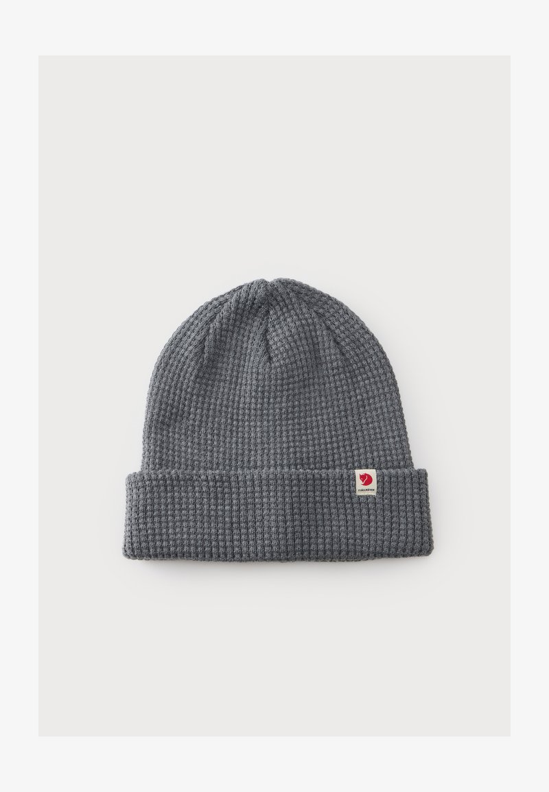 Bonnet gris tricoté avec revers plié et petite étiquette de logo rouge et blanc sur le revers, posé à plat sur fond blanc.
