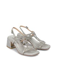 Sandales slingback en satin argenté avec un talon bloc. Présente des embellissements décoratifs liés avec des accents en cristal sur les sangles.