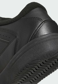 Scarpa sportiva nera con tomaia sintetica testurizzata, colletto imbottito e suola in gomma con motivo a onde per un miglior grip.