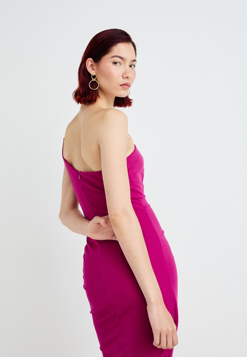 Vestido ajustado sin mangas de tejido rosa brillante. Cuenta con un cierre de cremallera sutil en la parte trasera. Textura suave con una silueta estilizada.