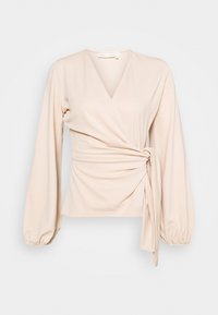 Top envolvente bege claro com mangas bufantes longas, decote em V profundo e detalhe de laço na cintura franzida. Feito de um tecido suave e elástico.