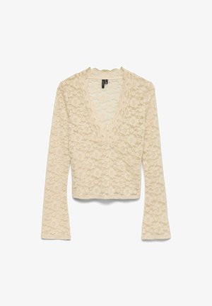 Top de encaje beige de manga larga con escote en V. Presenta un patrón floral texturizado, longitud cropped y material suave y delicado.