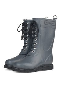 Bottines en caoutchouc grises avec une finition brillante, dotées de lacets noirs, d'œillets argentés et d'une languette à l'arrière pour un enfilage facile.