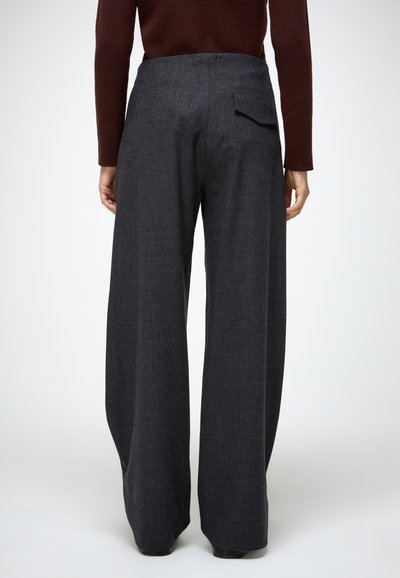 Laia jalad tumedast hallist kangast, millel on kõrge vöökoht ja tagatasku. Sile tekstuur koos kohandatud disainiga.