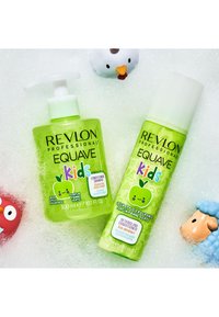 Shampoo et après-shampooing démêlant Revlon Equave Kids, tous deux en bouteilles vert vif, avec un design de pomme de dessin animé et une texture douce.