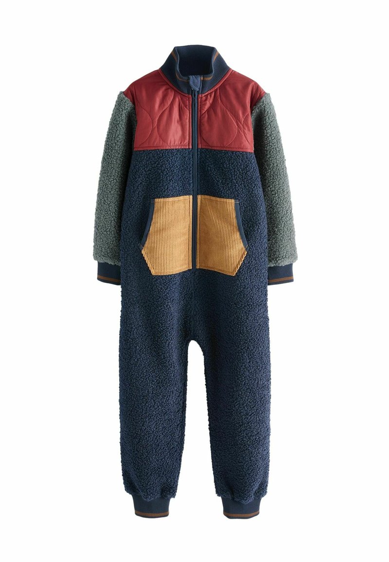Tuta in pile di colore blu navy con pannello trapuntato rosso e maniche verdi. Presenta tasche in corduroy e polsini a coste per calore e comfort.