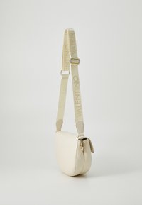 Kremfarget crossbody-veske med en glatt lærfinish, med en beige stropp merket med "VALENTINO" i gull, og en glidelås-lukking.