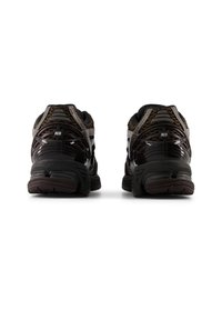 Μαύρα αθλητικά παπούτσια με πανέλα από πλέγμα, καμπυλωτό σχέδιο στη φτέρνα και ανθεκτική σόλα από καουτσούκ. Διακριτικό λογότυπο "N" στη φτέρνα. Υφή με γκρι λεπτομέρειες.